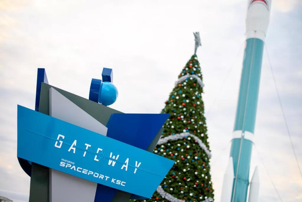 Christmas Decorations at Kennedy Space Center The Gateway Deep Space Launch Complex sign in front of a large Christmas tree