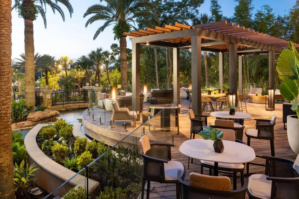 JW Marriott Resort An outdoor seating area at dusk, surrounded by palm trees and rocks
