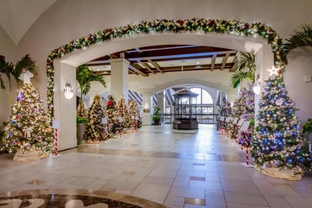 Rosen Hotels at Christmas A hotel lobby lined with decorated and lit Christmas tree and Christmas garlands