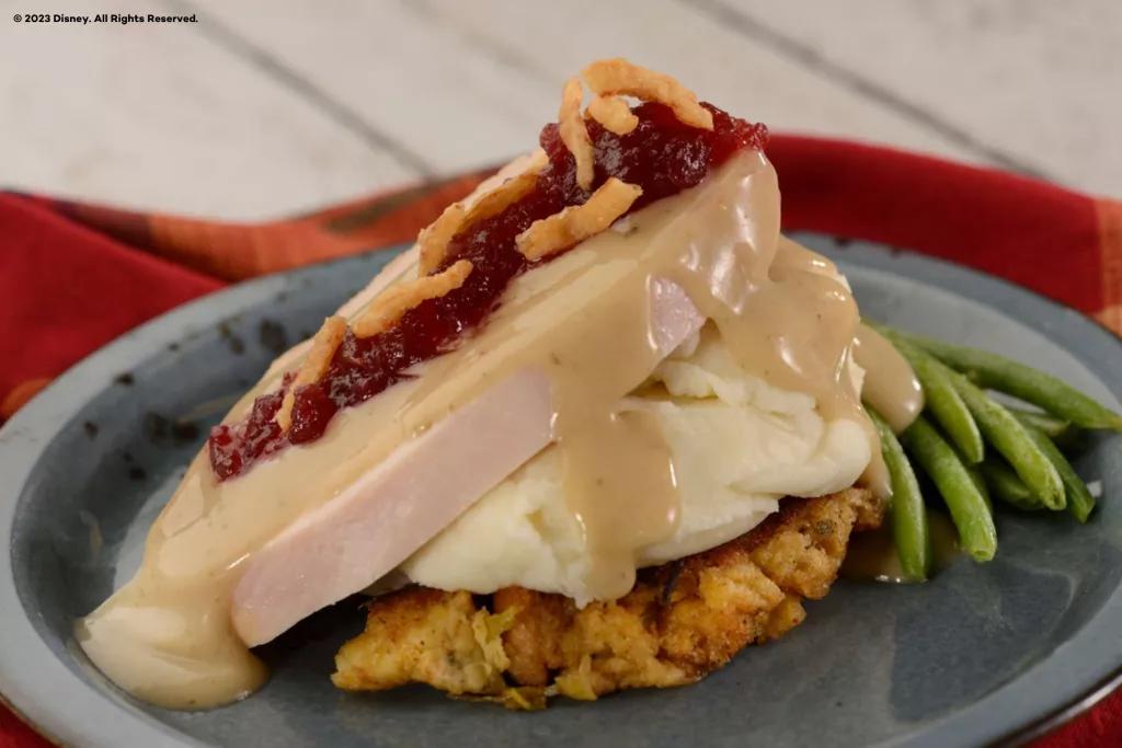 Holiday Kitchens at Festival of the Holidays A small Thanksgiving meal on a plate, including turkey, stuffing, mashed potatoes, gravy and cranberry sauce