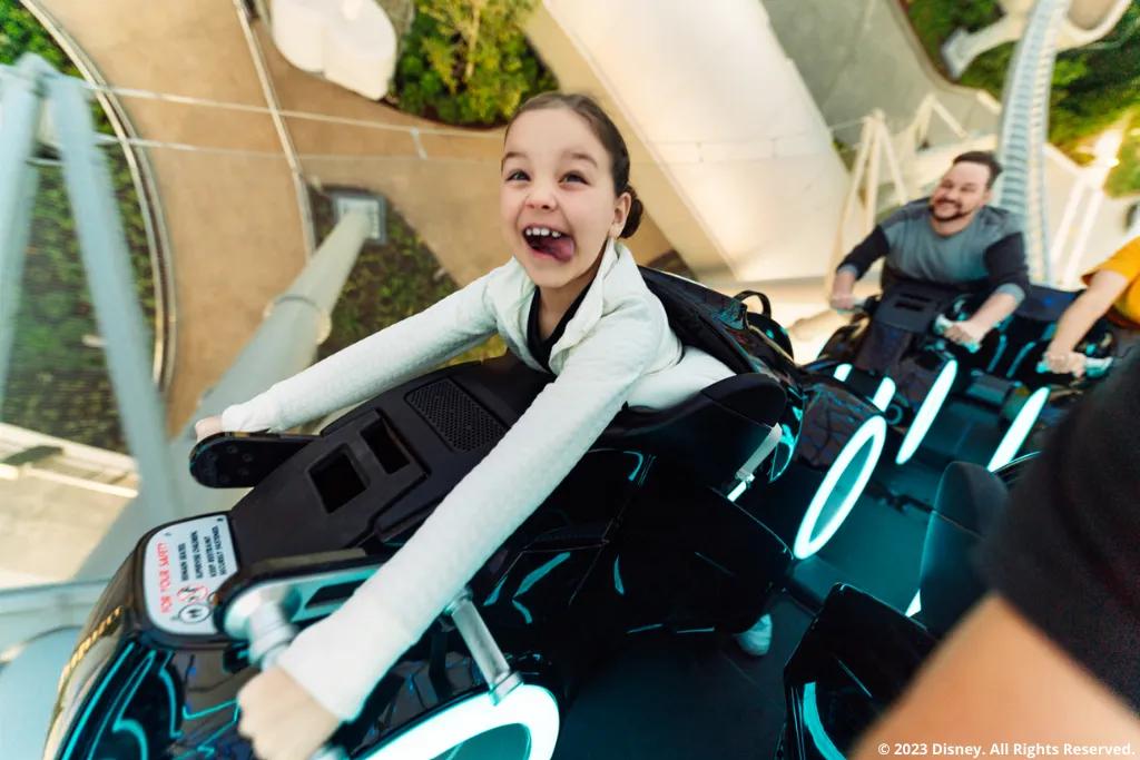 Child on TRON Lightcycle / Run in Magic Kingdom Park Ein Kind fährt die neue Magic Kingdom Park Attraktion TRON Lightcycle / Run und streckt die Zunge heraus
