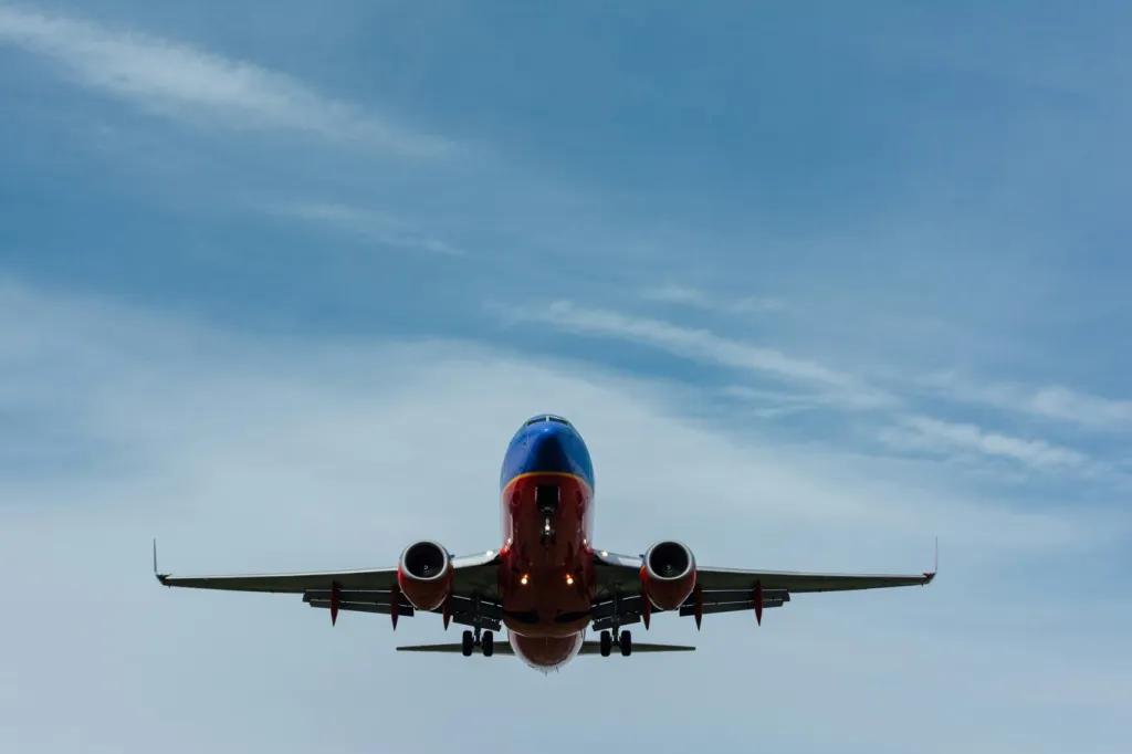 Flights to Orlando Looking up at a plane flying through a blue sky