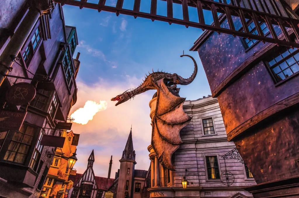 Wizarding World of Harry Potter A dragon on top of a building breathing fire into the sky at sunrise