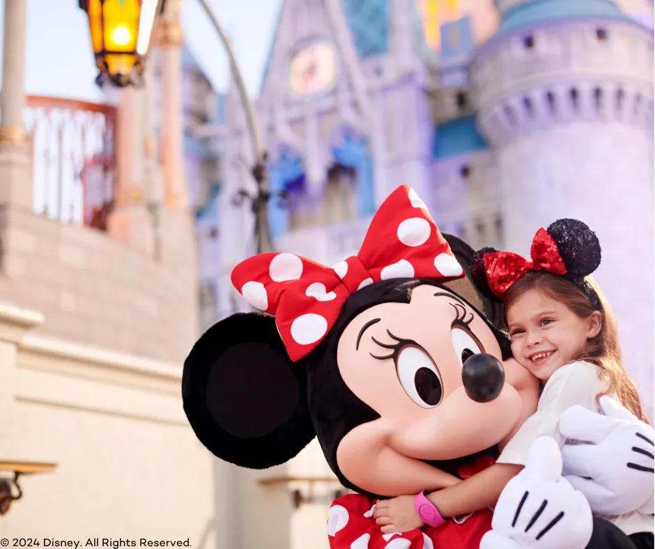 Minnie Mouse with guest Minnie Mouse hugging guest in front of Cinderella's castle
