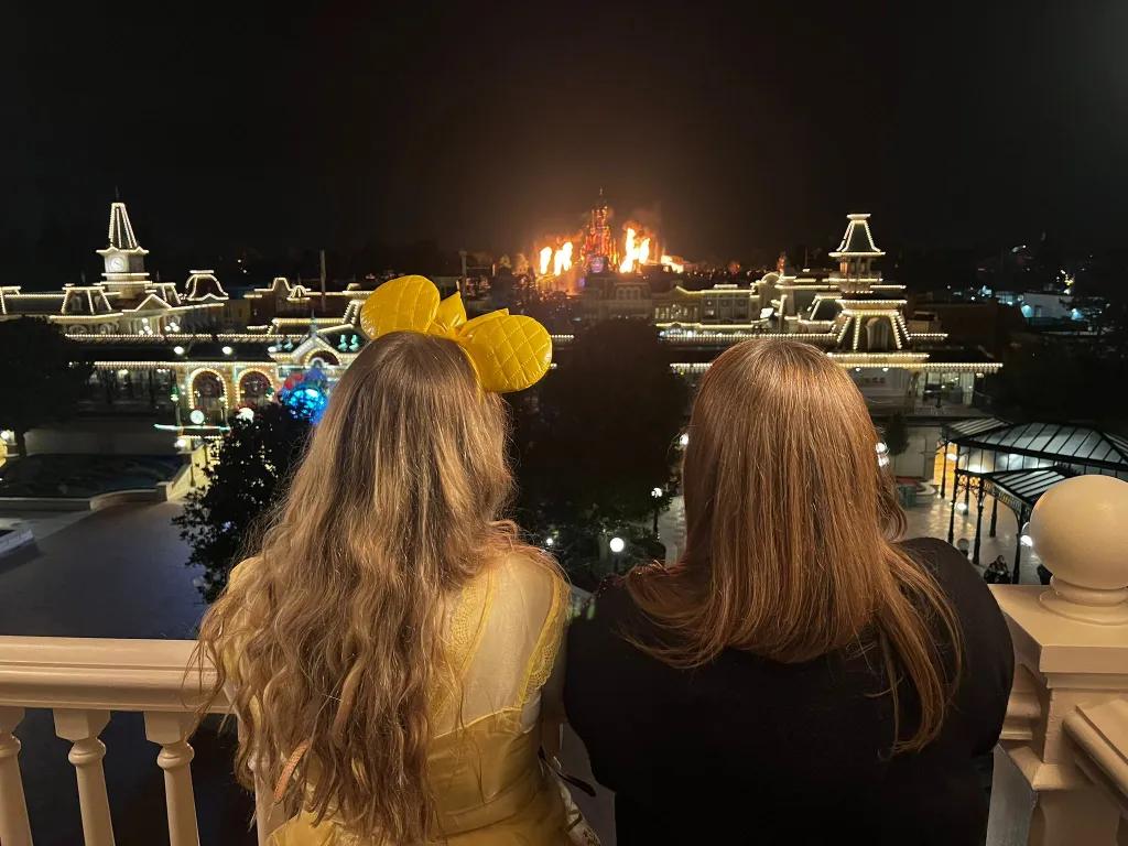 Disney Dreams from the Disneyland Hotel Two women facing away from the camera watching a fireworks display at a Disney park