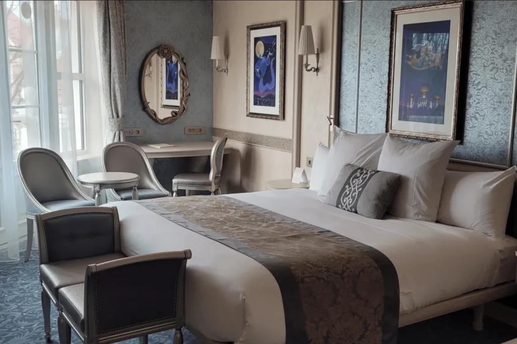 Disneyland Hotel Room A hotel room with a king-sized bed in the centre next to a balcony door and a table and chairs