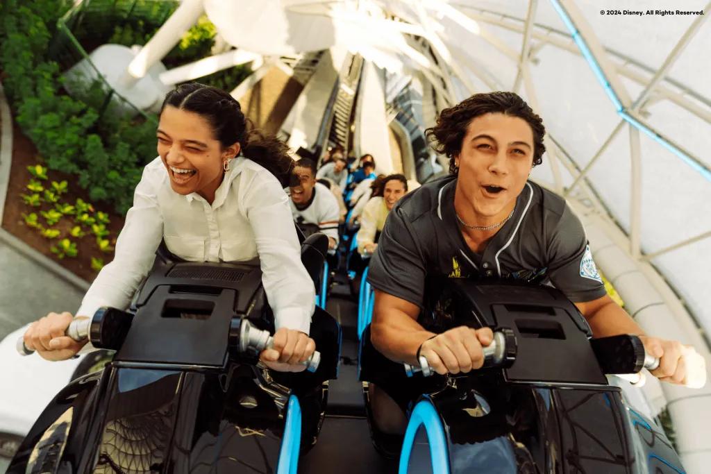 TRON Lightcycle/Run Two adults on a motorcycle-shaped ride vehicle on a rollercoaster