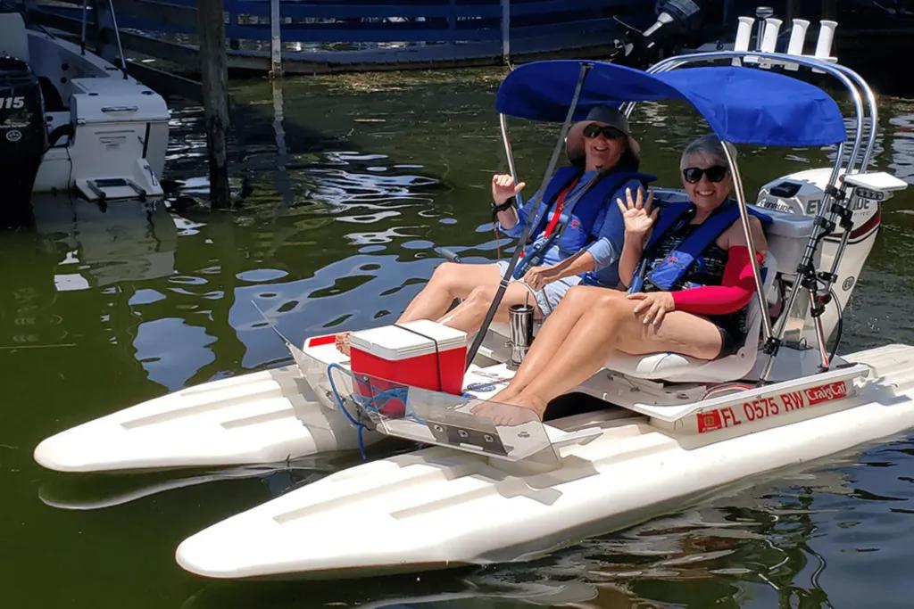 CatBoat Adventure Tours Two women waving at the camera from a small boat