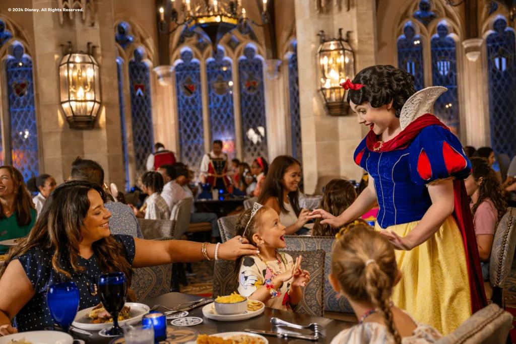 Cinderella's Royal Table Snow White meeting a family sitting at a table eating dinner