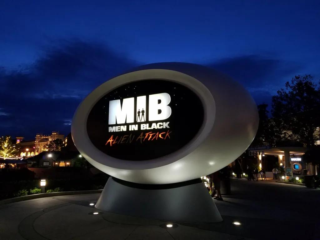 Men in Black: Alien Attack Dark sky in the background with blue hue, with a sign saying "M.I.B. Men in Black Alien Attack"