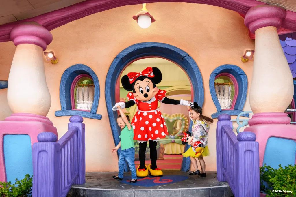 Dancing with Minnie Mouse at Disneyland Two young girls dancing with Minnie Mouse on the steps of her house at Disneyland