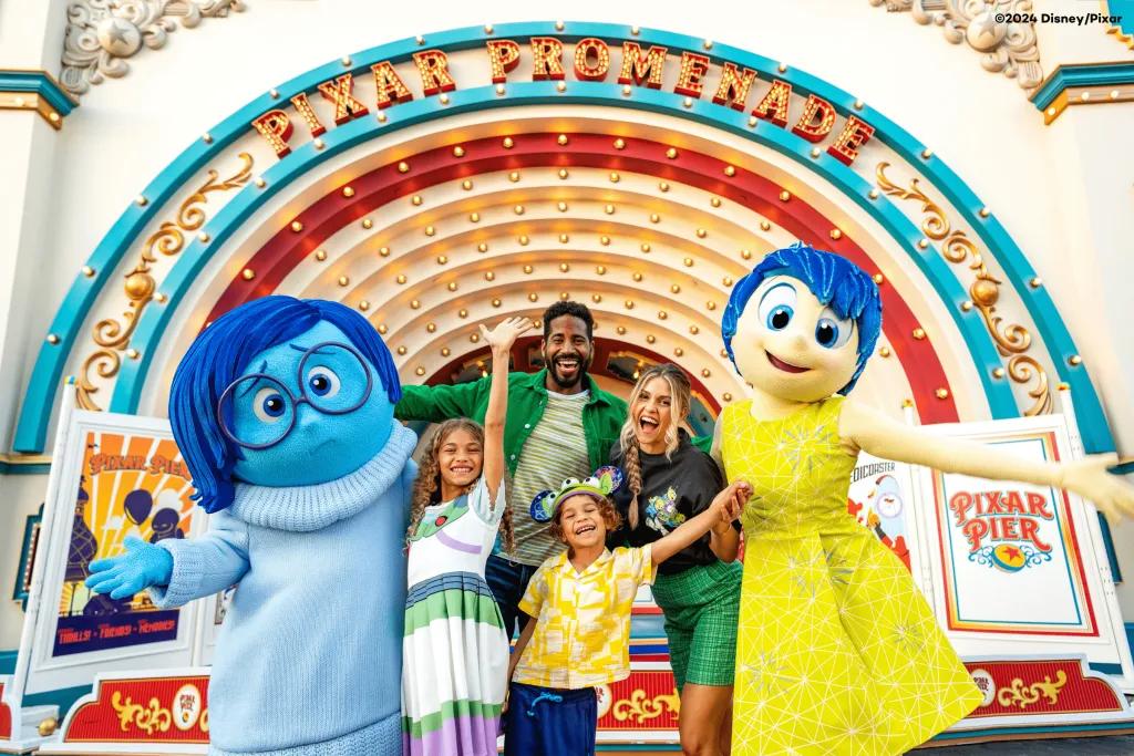 Pixar Fest at Dinseyland Resort in California A family posing with Joy and Sadness from Inside Out at Pixar Pier