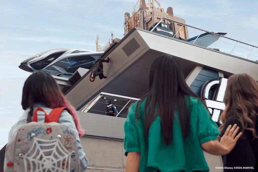 Avengers Campus in Disneyland Kalifornien Drei Frauen schauen den Superhelden zu, die auf einem Gebäude des Avengers Campus klettern