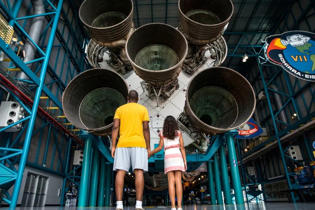 Kennedy Space Center Visitor Complex Father and daughter looking up at the Saturn V Rocket at Kennedy Space Center