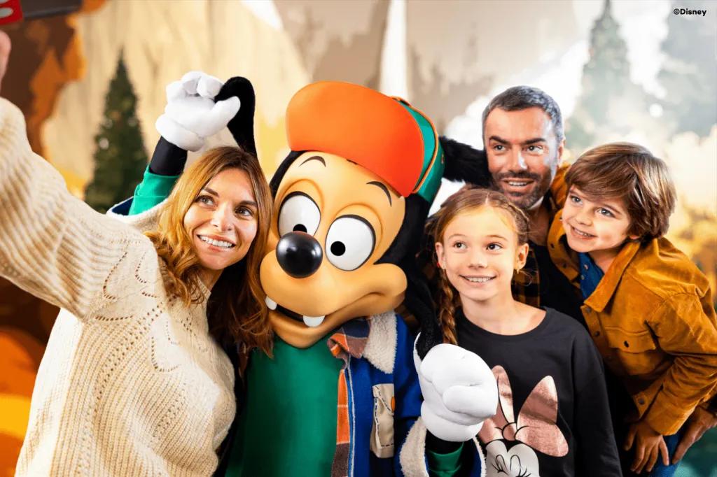 Max Goof at Disneyland Paris A family taking a selfie with Max Goof wearing a hat and winter coat
