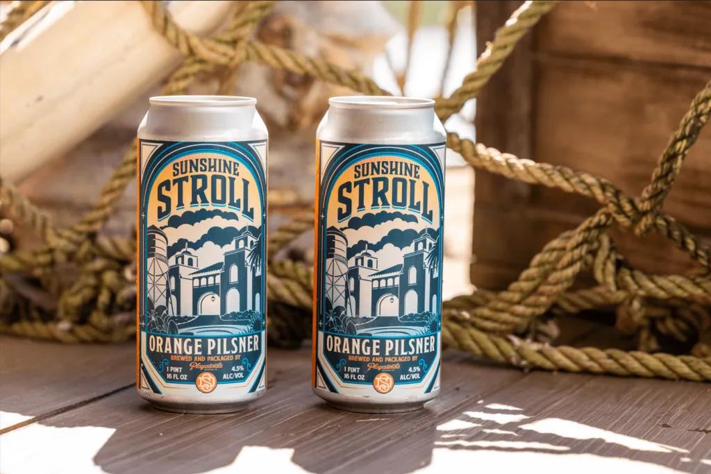Sunshine Stroll Pilsner Two cans of Sunshine Stroll pilsner on a decking with rope in the background