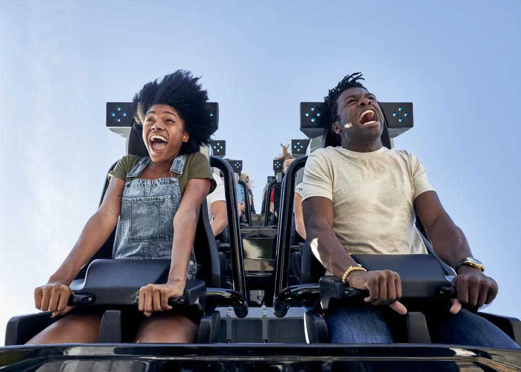 VelociCoaster in Universal Islands of Adventure Two people screaming on a rollercoaster with only lap bars holding them in. They are looking down in shock ready to fall.