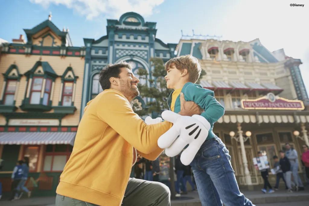 Main Street USA A dad and young son about to hug while standing on Main Street USA