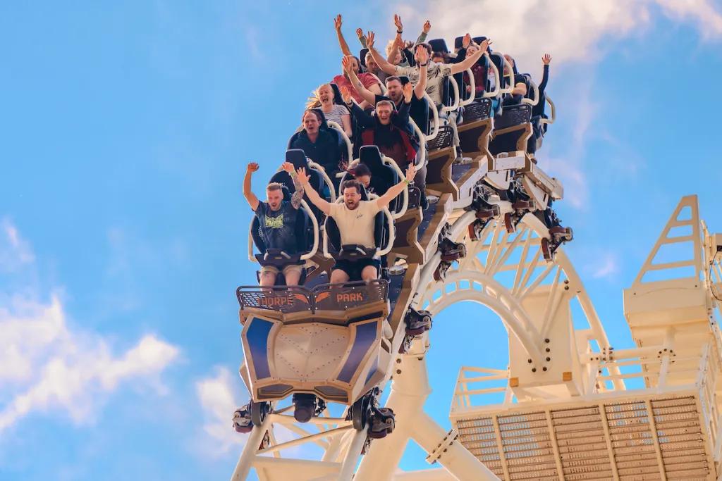 Hyperia at Thorpe Park A ride train full of people with their hands in the air going over a hill on a rollercoaster