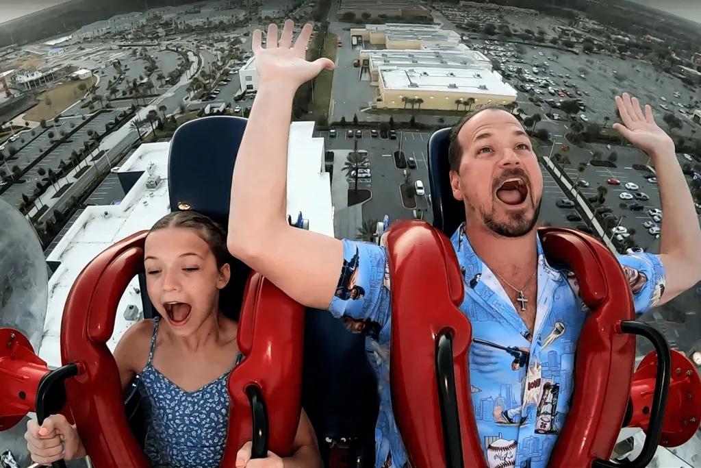 Sunset Walk Slingshot A man and young girl screaming on a slingshot ride