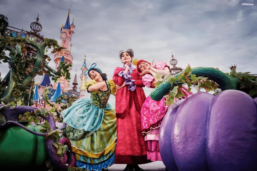 Disney Villains at Halloween Cinderella's stepsisters and stepmother posing behind large pumpkins in front of Sleeping Beauty Castle