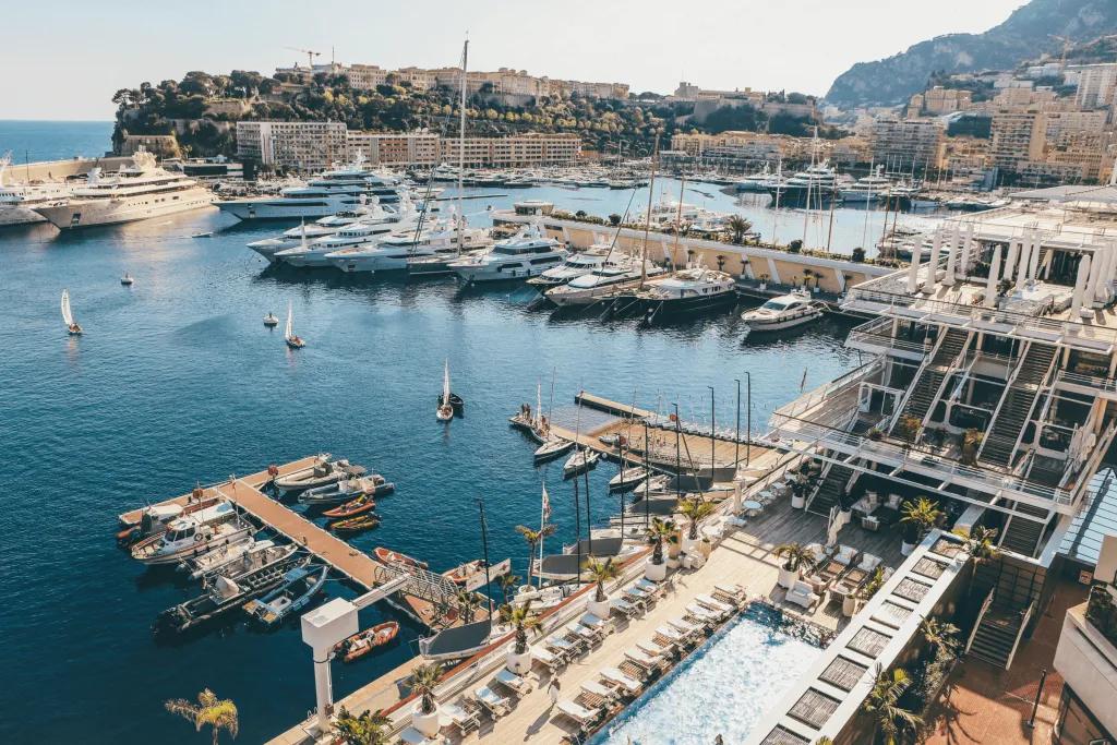 Monaco Many yachts docked up in the Monaco harbour. Behind there is a pretty mountain.
