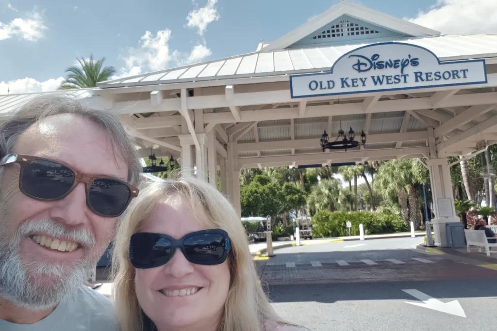 Disney's Old Key West Resort Man and woman taking a selfie in the road with a small wooden roof over it and a sign saying "Disney's Old Key West Resort"