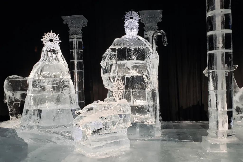 ICE! at Gaylord Palms Resort Ice sculpture of nativity scene, including Mary, Joseph and baby Jesus laying in a cot in a stable.