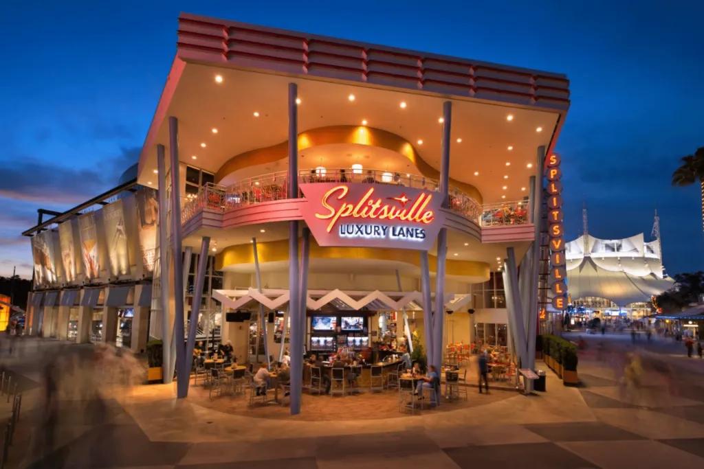 Splitsville Large modern building with bar outside and people sat drinking. There is a giant neon red sign saying 'splitsville luxury lanes' on it.