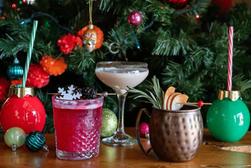 JW Marriott Orlando Christmas Behind there is a christmas tree with baubles of different colours. There are also 5 different cocktails in different glasses.