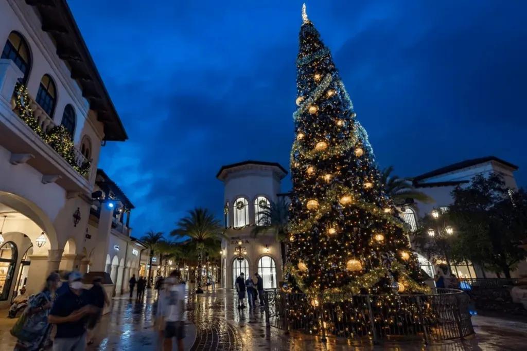 Disney Springs zu Weihnachten Das festlich dekorierte Disney Springs mit einem geschmückten Tannenbaum bei Nacht