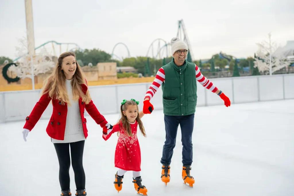 SeaWorld Orlando zu Weihnachten Eine Familie mit einem kleinen Mädchen läuft in SeaWorld Orlando Schlittschuh