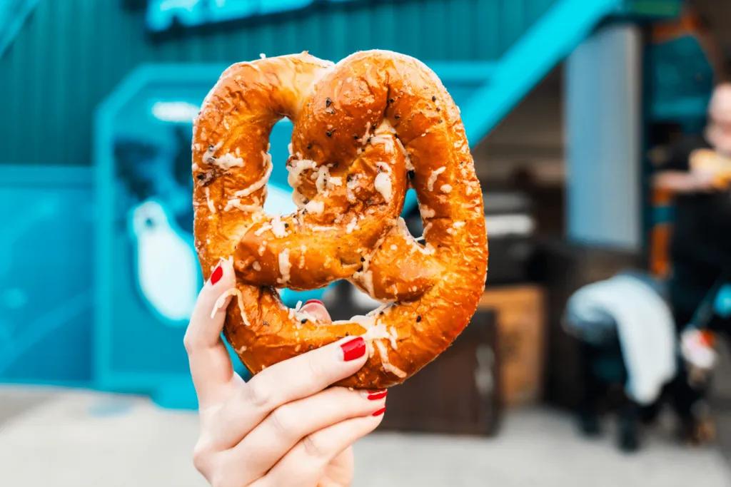 SeaWorld Pretzel Hand holding up a SeaWorld Pretzel in front of a blue building