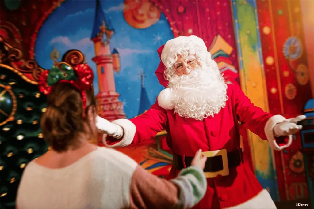 Meeting Santa at Disneyland Paris Santa holding his arms out towards a woman walking towards him