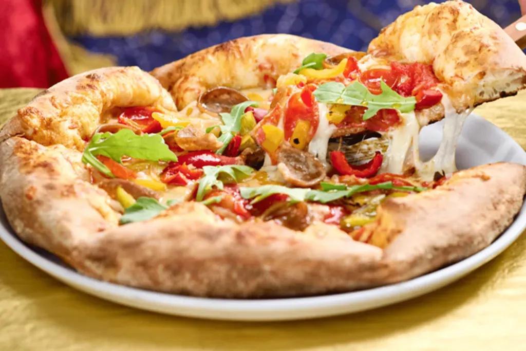 Vegane Harvest Moon Pizza Vegetarische Pizza mit viel Gemüse wie Paprika, Oliven und Artischocken.