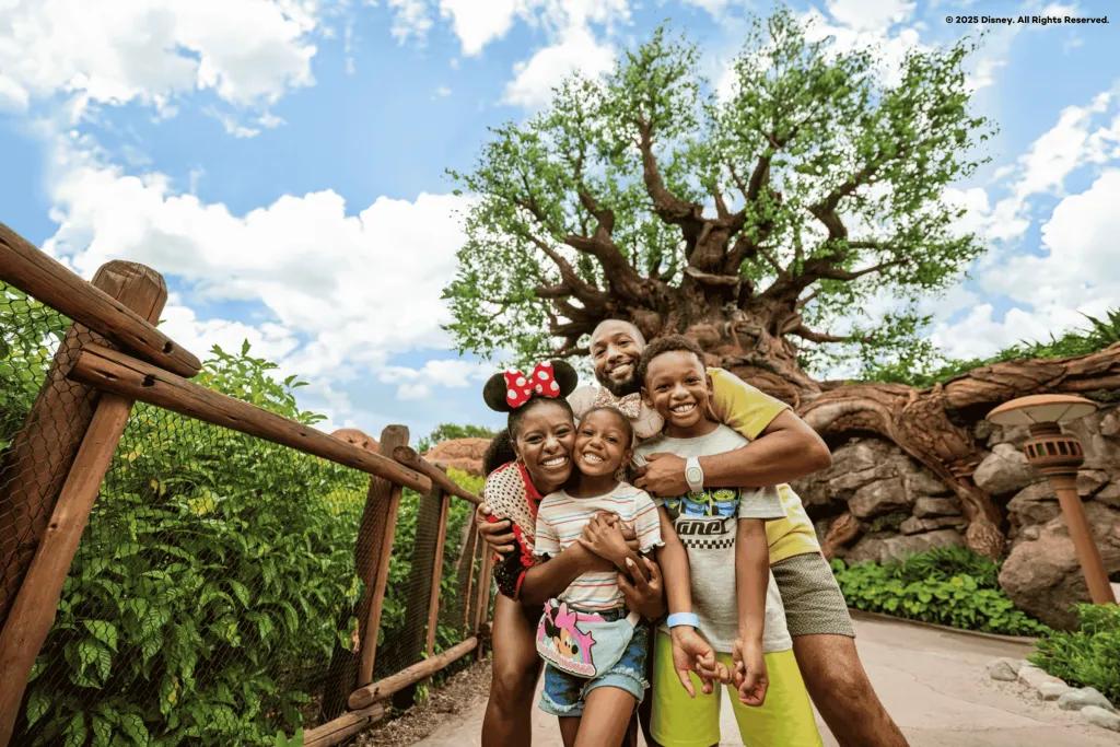 Disney's Animal Kingdom Theme Park A family of four posing in front of the Tree of Life in Animal Kingdom