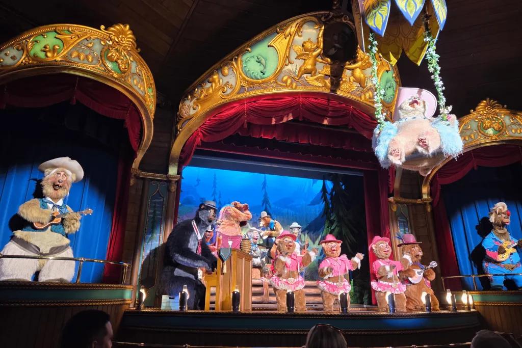 Country Bear Jamboree Bears on stage wearing different costumes. One swinging on a swing above the audience.