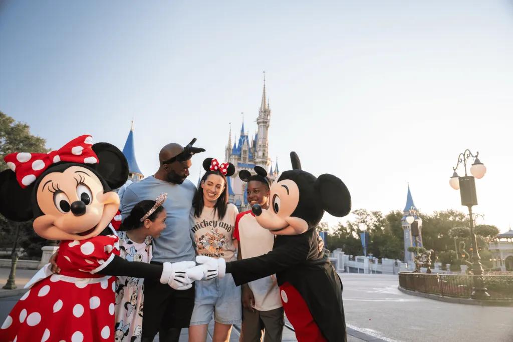 Mickey and Minnie at Walt Disney World Resort A family hugging Mickey and Minnie Mouse in front of Cinderella Castle