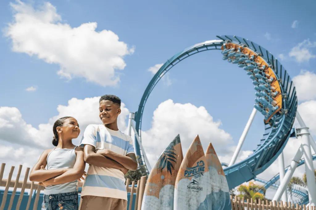 SeaWorld Orlando Two children posing in front of a surf-themed rollercoaster
