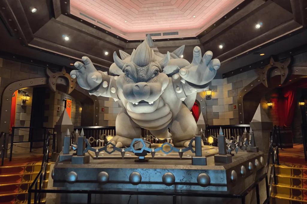 Mario Kart: Bowser’s Challenge Statue of a weir creature called Bowser from Mario Kart, a turtle like creature with shell but the face is a bit scarier. The queue wraps around this statue.