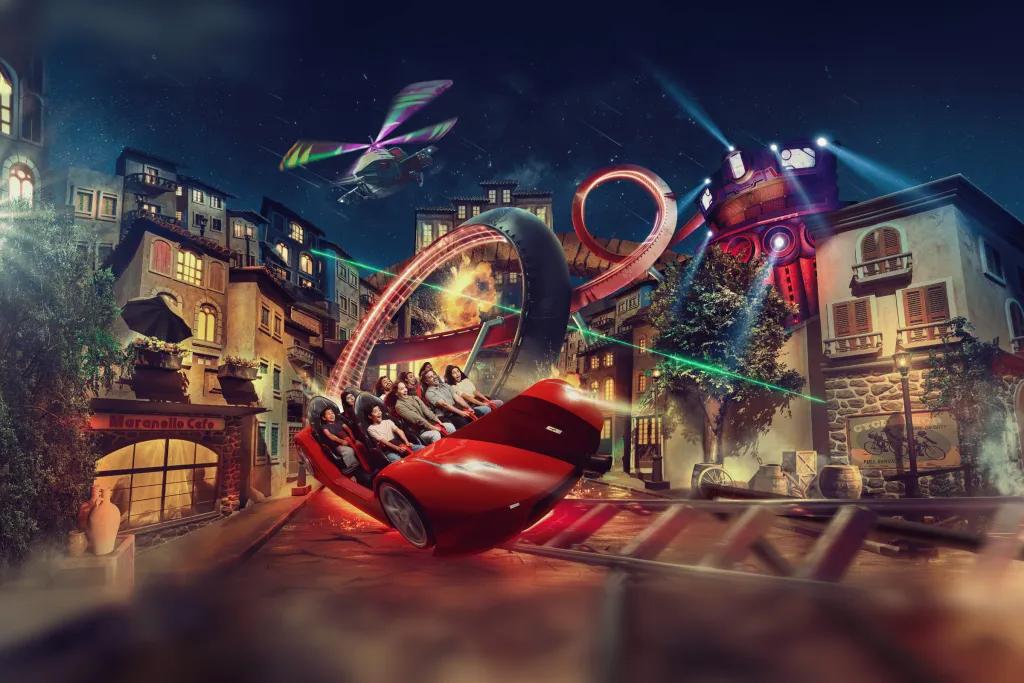 Mission Ferrari A red simulator styled ride with buildings either side of the track and a helicopter flying overhead.