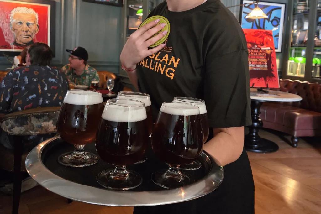 Raglan Road Woman holding a tray of 5 beers wearing a Raglan Road t-shirt.