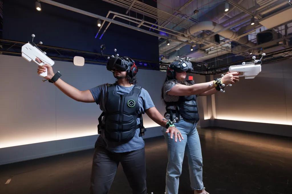 Sandbox VR A man and woman standing next to each other in a VR experience