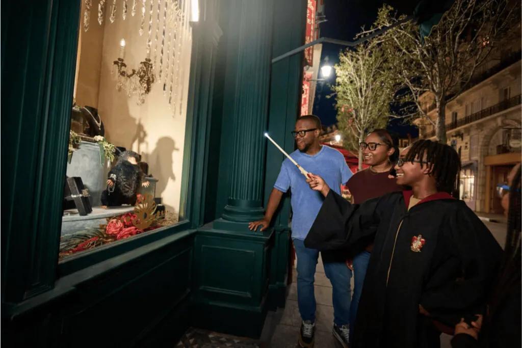 Guests engaged in the interactive wand experience, showing a child using the wand to activate a display, highlighting the immersive magic of The Wizarding World of Harry Potter at Universal Studios Florida.