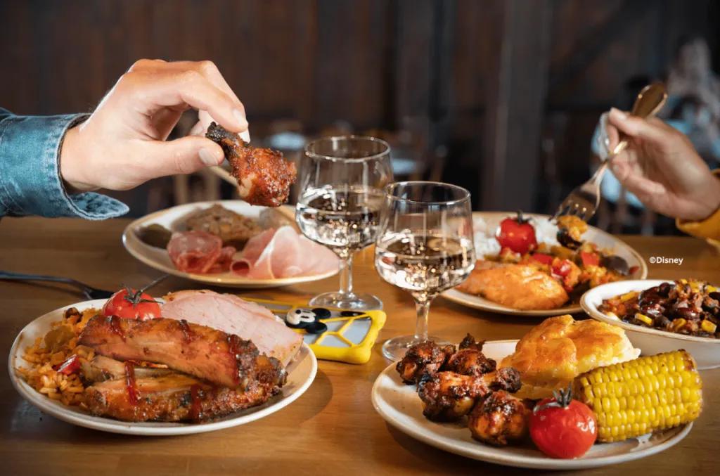 Plates featuring barbecue ribs, chicken, and corn, representing a relaxing dining experience at Disney Village, Disneyland Paris.