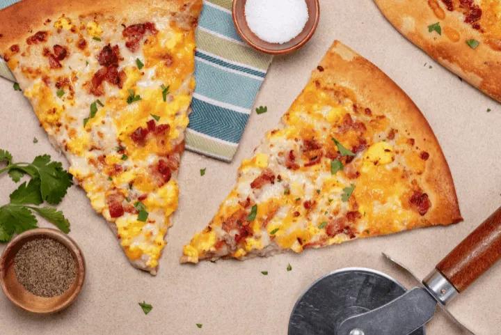 Two slices of pizza with a pizza cutter