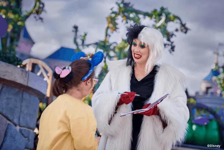 Guest meeting Cruella de Vil, who is signing an autograph, at the Disney Halloween Festival