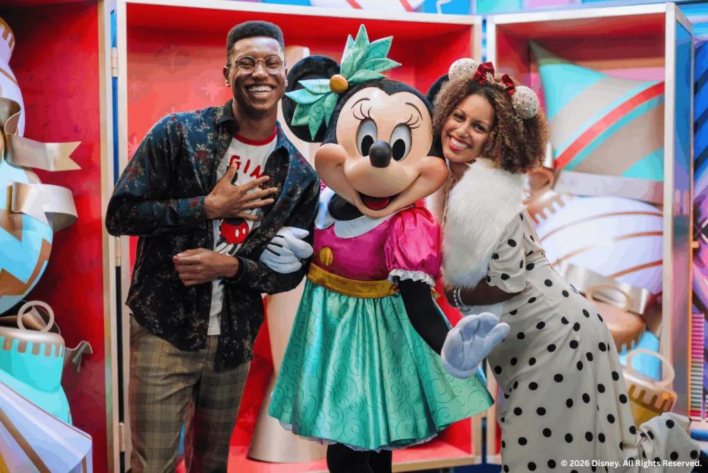 Two guests posing with Minnie Mouse in a festive holiday setting