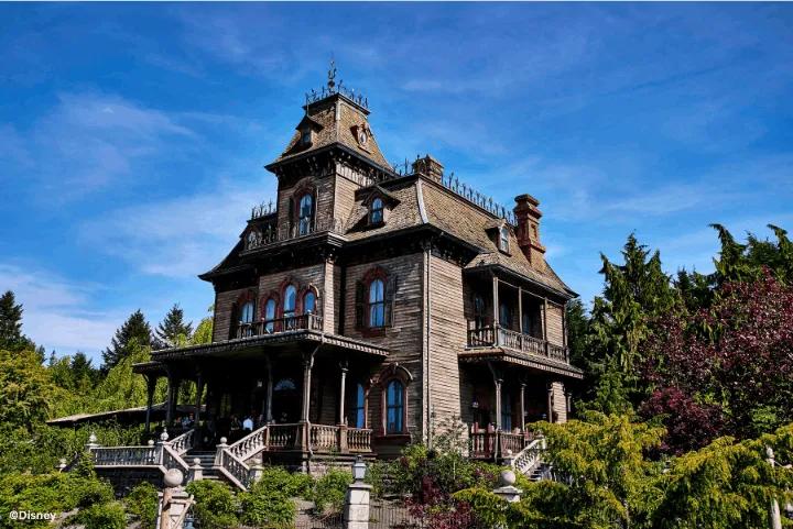 Phantom Manor's weathered Victorian mansion exterior at Disneyland Paris under a clear blue sky