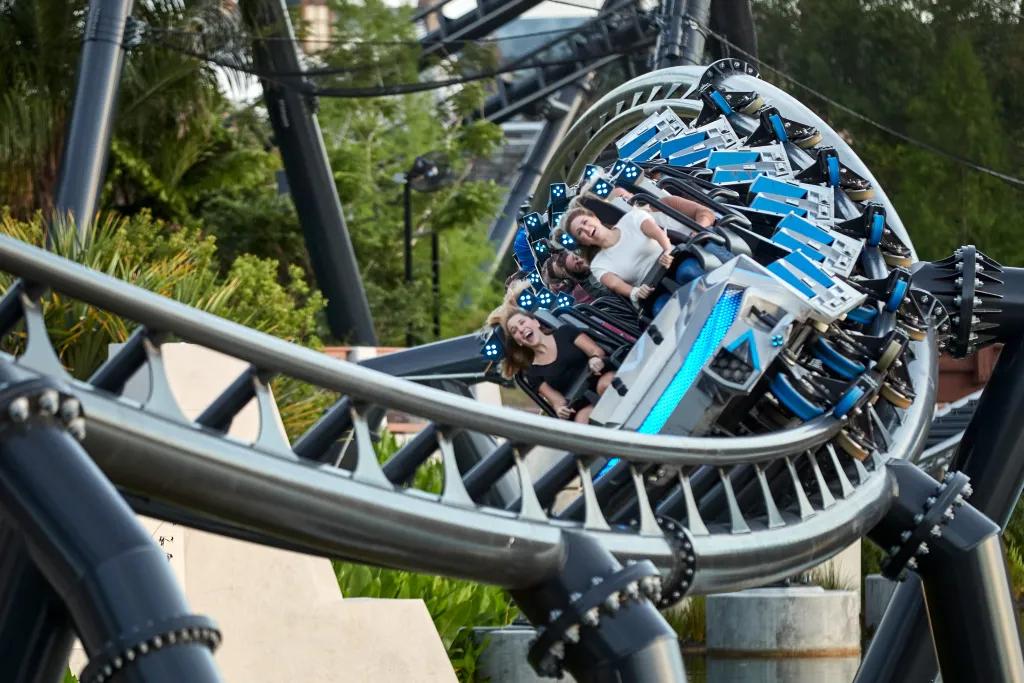 Riders screaming through a vertical loop on Jurassic World VelociCoaster